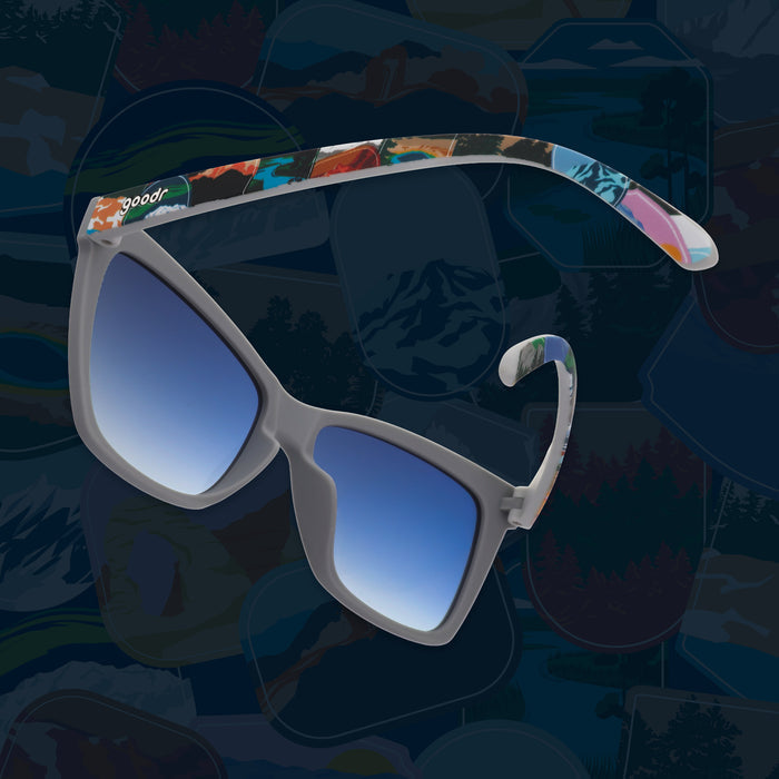 Side view of gray sunglasses with blue gradient lenses and colorful National Park Foundation temples.