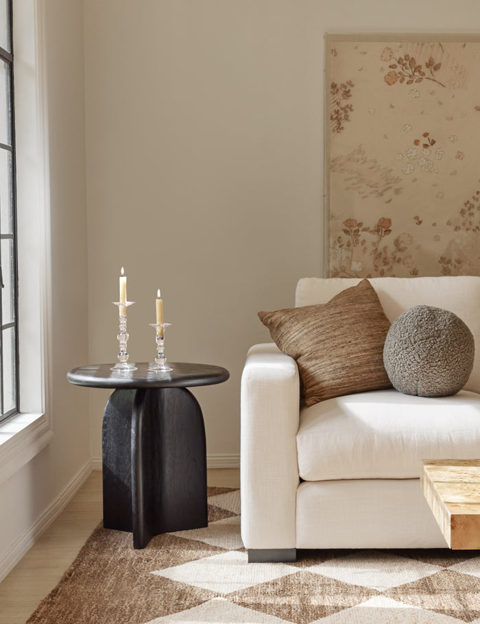 #showall::39723799281763 | Khaki gray Bouclé Ball Pillow by Sarah Sherman Samuel sits on an ivory couch next to a black side table and atop a patterned rug
