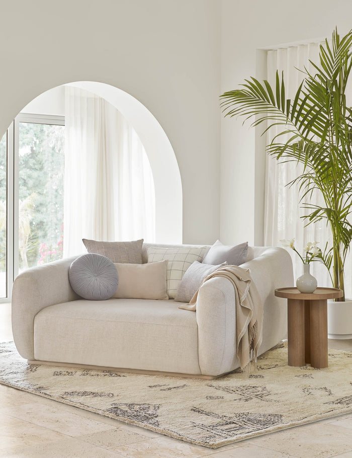 #color::ice-blue #style::square | The claudette blue square pillow sits atop an ivory linen media lounger in a room with high white  | ceilings and a plush ivory rug