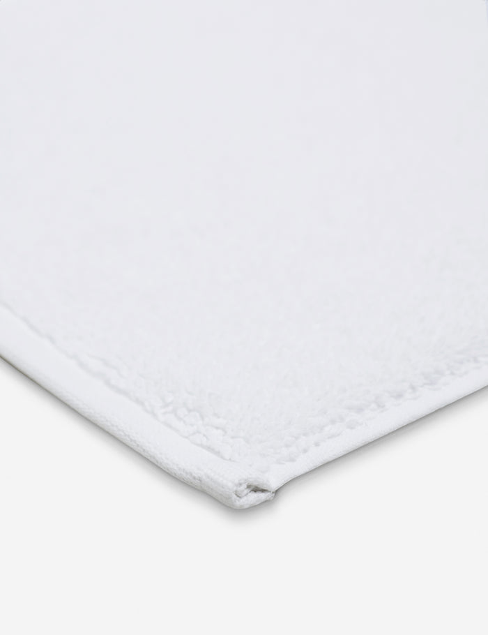 #color::white | Corner shot of the Cloud loom sustainable white bath mat by coyuchi