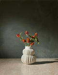 #color::white | Delilah white ceramic vase featuring two rows of half-moon discs fanned around a tapered body with flowers inside of it