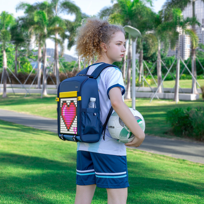 Divoom Backpack-S Pixel Art LED Backpack, a pink pixel heart display worn with a soccer ball in a sunny park, smartphone app controlled, sports practice decor