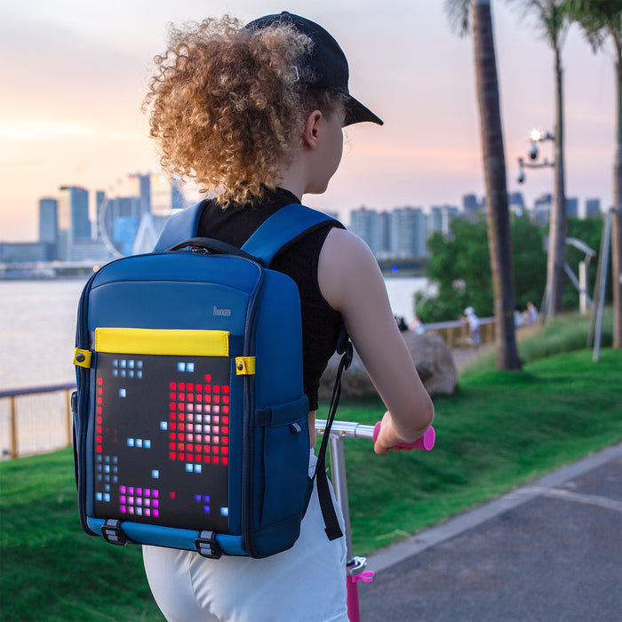 Divoom Backpack-S Pixel Art LED Backpack, a blue backpack worn while riding a scooter with red pixel art, smartphone app controlled, sunset waterfront commute decor