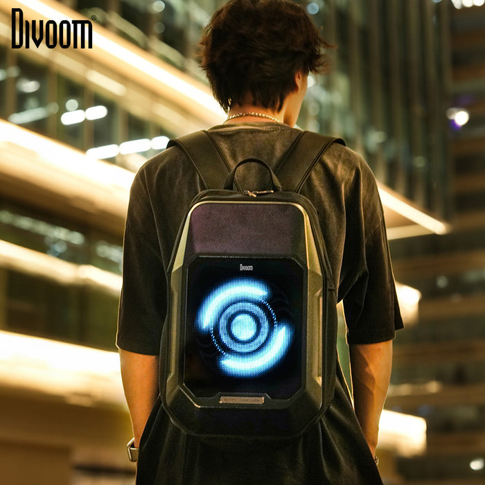 Divoom Cyberbag Pixel Art LED Backpack, worn on the back with a glowing blue circular pixel animation in a city night setting, smartphone app controlled, urban streetwear decor