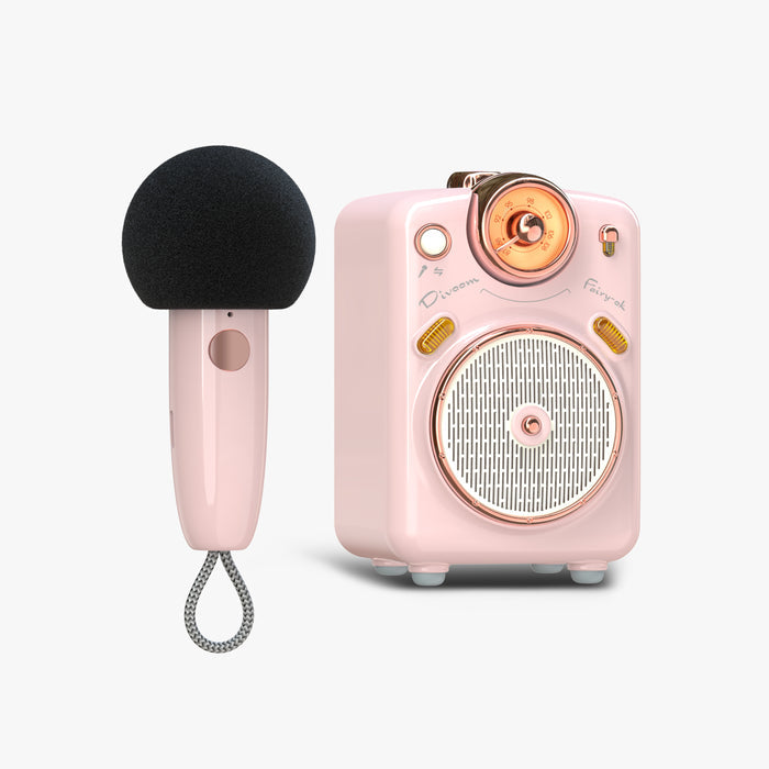 Divoom Fairy-OK Retro Mini Karaoke Speaker, a pink retro speaker with rose gold dial and matching wireless microphone on a plain background, audio-ready bedroom decor
