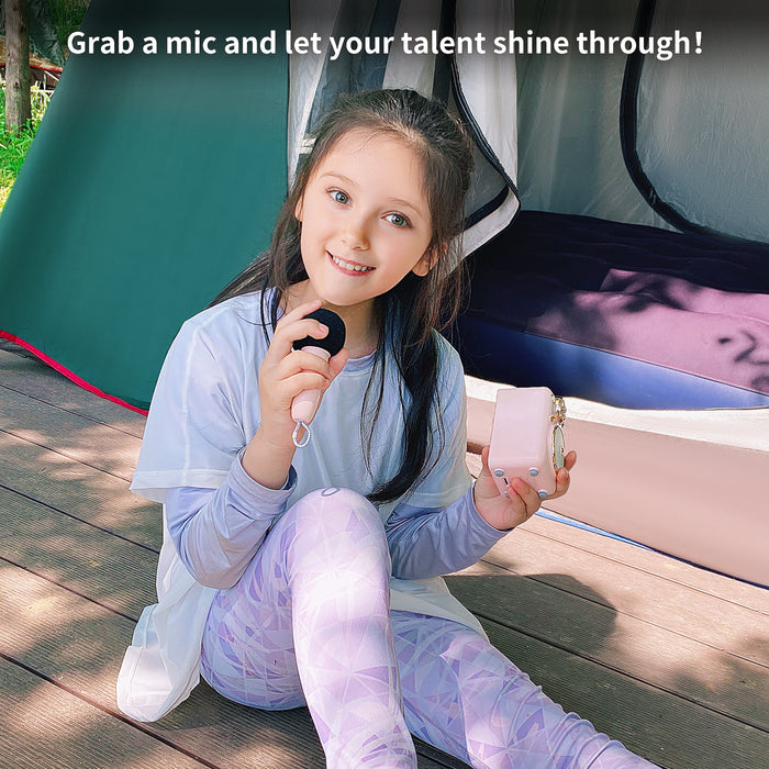 Divoom Fairy-OK Retro Mini Karaoke Speaker, a girl holding the pink mini speaker and microphone beside a tent, portable audio for outdoor camping decor