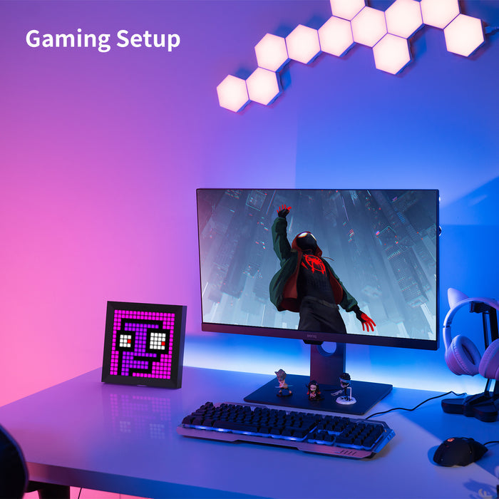Divoom Pixoo 16x16 pixel art LED display, a pink pixel face beside a gaming monitor and headset, smartphone app controlled, RGB gaming desk decor