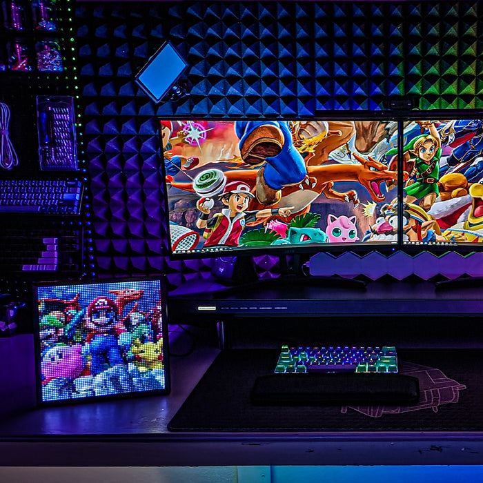 Divoom Pixoo64Ⅱ 64x64 Pixel Art LED Display Social Media Counter, colorful pixel game characters beside a dual-monitor gaming setup, smartphone app controlled, streamer desk decor