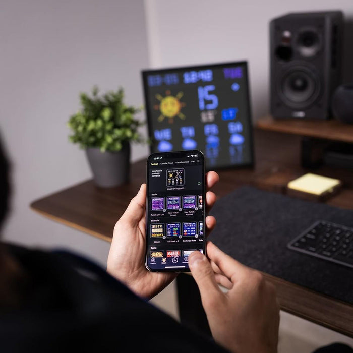 Divoom Pixoo64Ⅱ 64x64 Pixel Art LED Display Social Media Counter, a weather dashboard setup on a desk with app selection on phone, smartphone app controlled, home office decor
