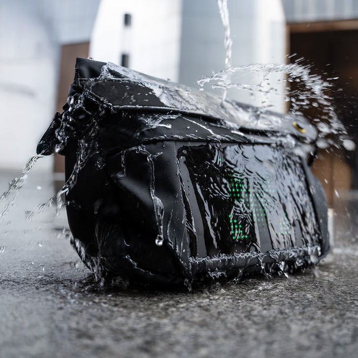 Divoom Sling Bag-V Pixel Art LED Sling Bag, a black LED sling bag splashed with flowing water and a green pixel icon, smartphone app controlled, rainy commute decor