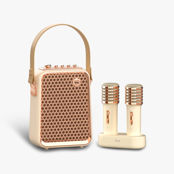 Divoom Songbird-HQ Portable Karaoke Bluetooth Speaker | Home KTV sound set, cream and rose gold speaker with carry handle, dual wireless microphones and charging dock on a clean background, Bluetooth audio for home karaoke party decor