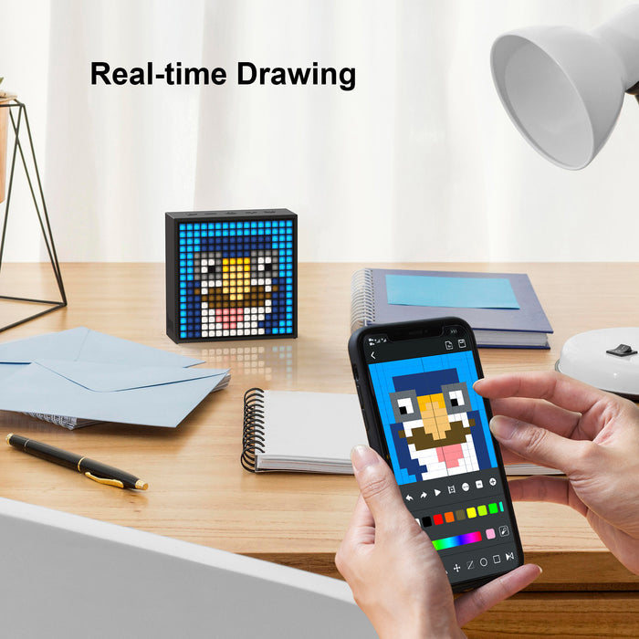 Divoom Timebox-Evo Pixel Art Speaker 16x16 DIY LED Display Alarm Clock Box, a blue penguin pixel drawing synced with a phone app on a desk, home office decor