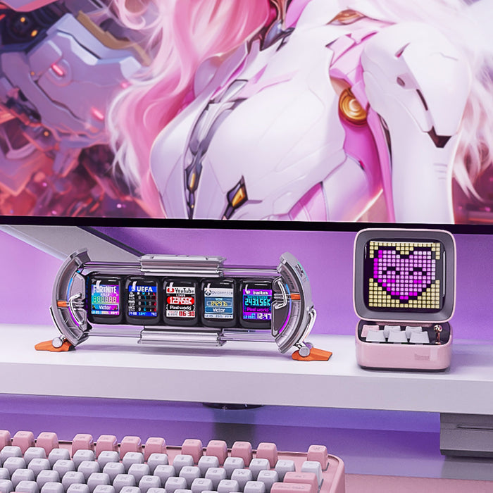 Divoom Times Gate & Ditoo Pro, silver multi-screen dashboard display beside a pink pixel speaker with a heart icon on a pastel RGB desk, smartphone app controlled, gaming setup decor