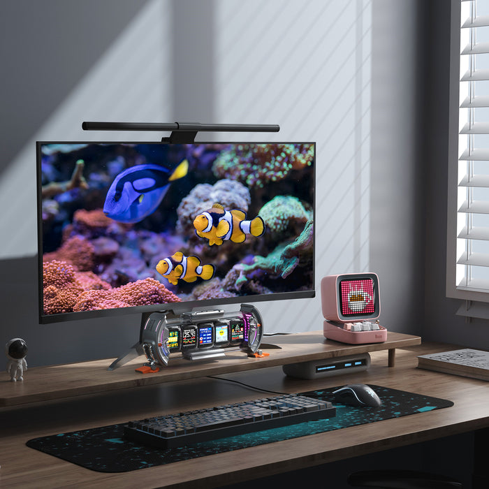Divoom Times Gate & Ditoo Pro, transparent dashboard display under a monitor and pink pixel speaker on a sunlit desk, smartphone app controlled, gaming setup decor