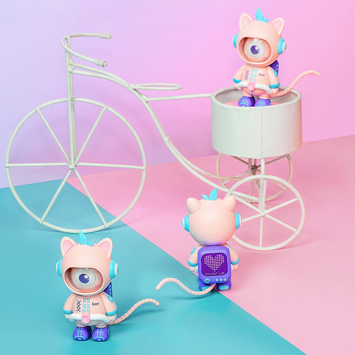 Divooo-The Divoom Mascot, three pink cat astronaut figures with a cyclops eye and pixel backpack posed around a white bicycle on pastel studio decor
