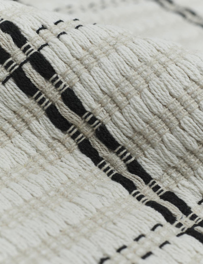 #size::1-9--x-2-10- #size::2--x-5- | Close up of the cotton material and black and white striped pattern on the Elin Bath Mat