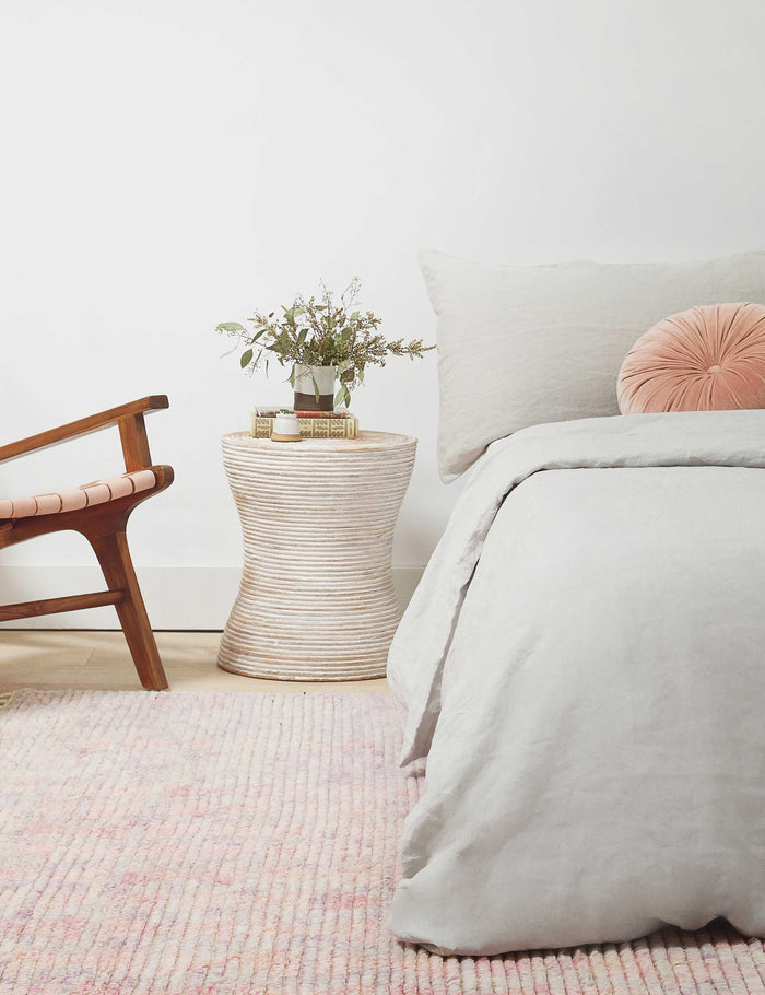 | Fenne round ribbed stone side table styled as a bedside table.