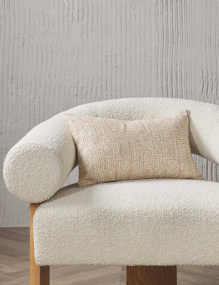 #size::12--x-20- | The Kisha natural-toned lumbar throw pillow sits on a cream boucle accent chair in a studio room