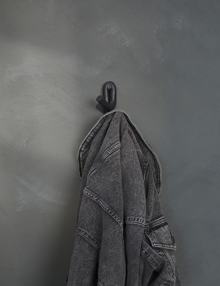 #color::black | Black Leggy Crossed Wall Hook by SIN Ceramics with a black jean jacket hanging on it