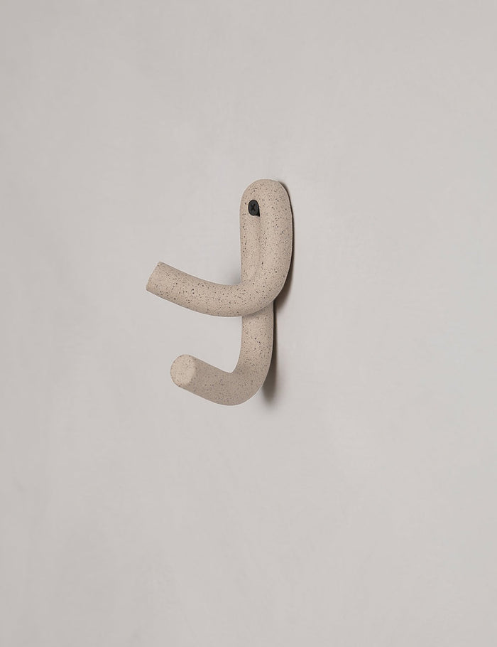#color::speckled | Cream speckled Leggy Crossed Wall Hook by SIN Ceramics hanging from a gray wall