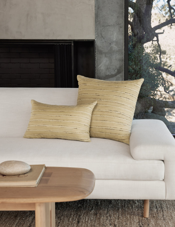 #size::12--x-20- #size::square | The leni silk pillow in both sizes sit together on a white linen sofa next to a wooden coffee table