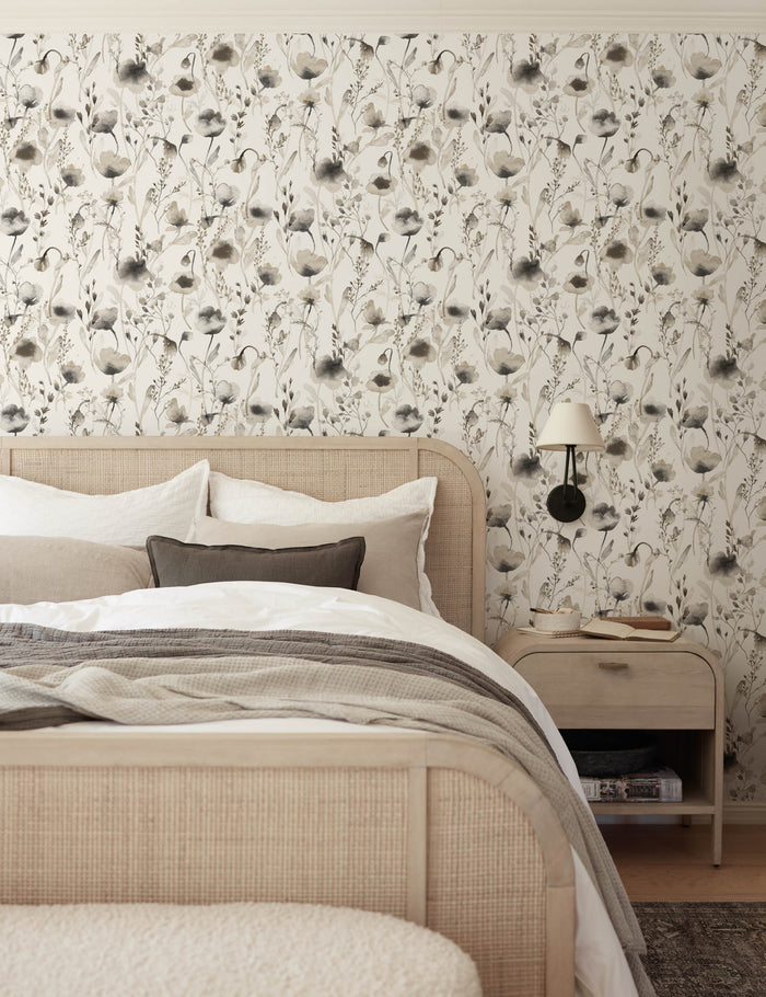 #color::brown | The Scalamandre Lo soft and pastoral brown toned floral wallpaper is in a bedroom with a cane and woven framed bed, gray toned bedding, and a whitewashed wooden nightstand