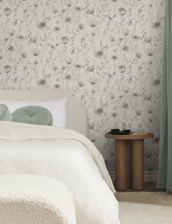 #color::pastel  | The Scalamandre Lo soft and pastoral gray toned floral wallpaper is in a bedroom with a natural linen framed bed, natural and cream toned bedding, and a wooden pedestal-base nightstand