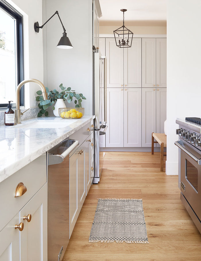 #size::1-9--x-2-10- #size::2--x-5- | The Masha gray and black geometric machine washable mats lays in a kitchen with stainless steal appliances and marble countertops