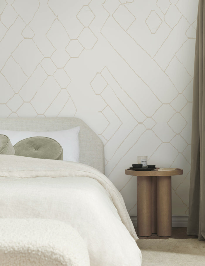 #color::natural | The Moroccan beige and ivory Wallpaper Mural by Sarah Sherman Samuel is in a bedroom with a talc linen bed, sage green velvet disc throw pillows, and a wooden nightstand with a sculptural base.