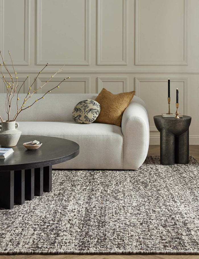 #color::espresso #size::10--x-14- #size::2-6--x-8- #size::6--x-9- #size::8--x-10- #size::9--x-12- #size::12--x-15- | The Taos espresso rug lays in a living room with accented walls under a round coffee table and an ivory sectional