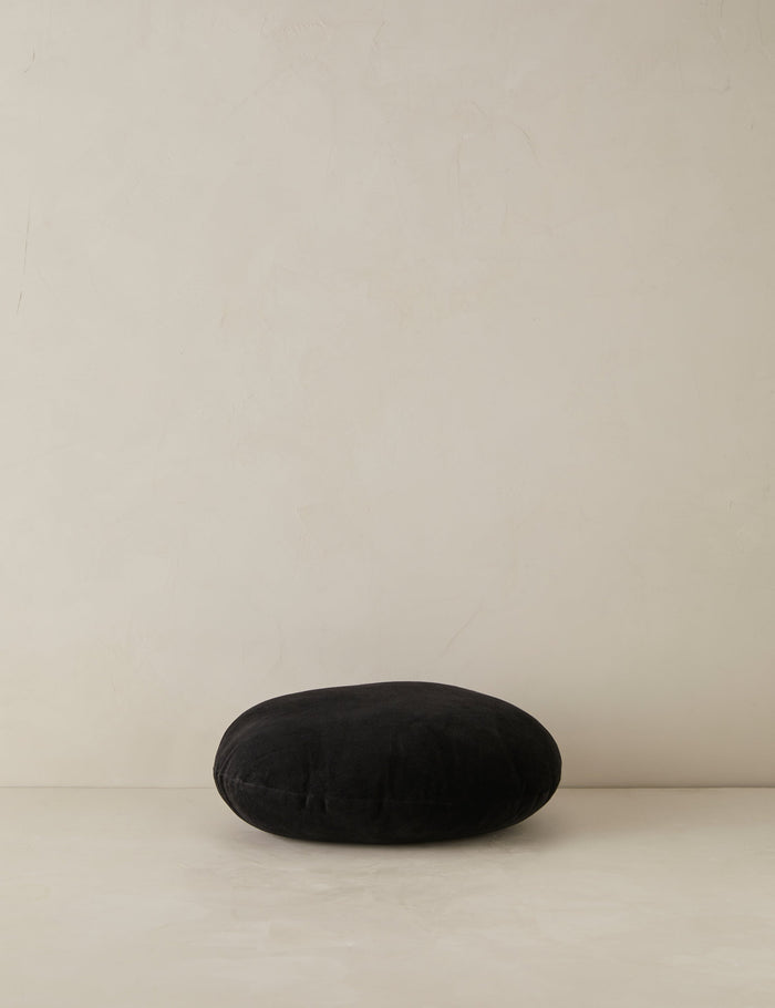 #color::black | Velvet round accent pillow in black laying flat