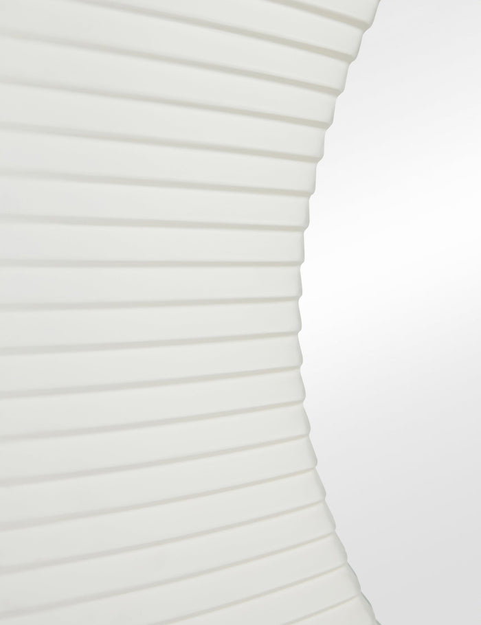 #color::white | Close up of the Whitaker white asymmetrical oval wall mirror.