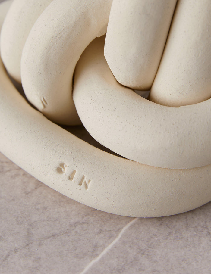 #color::bone | Close up view of the decorative ceramic double coil XL Fist Knot by SIN Ceramics